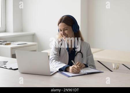 Buona donna medico che parla con il paziente in videochiamata Foto Stock