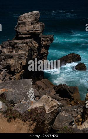 Pile stratificate e colonne marine, scolpite in forme curiose dalle onde e dal vento, sono sparse lungo l'aspra costa di Cabo Carvoeiro a Peniche nel distretto di Leiria, Portogallo centrale. Gran parte della roccia sedimentaria fu posata nell'epoca del primo Giurassico, fino a 200 milioni di anni fa. Foto Stock