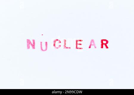 Stampa in gomma con inchiostro rosso in parola nucleare su sfondo bianco Foto Stock