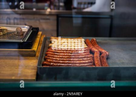 Salsiccia viennese alla griglia in un bar a Naschmarkt, mercato di Street food a Vienna, Austria Foto Stock