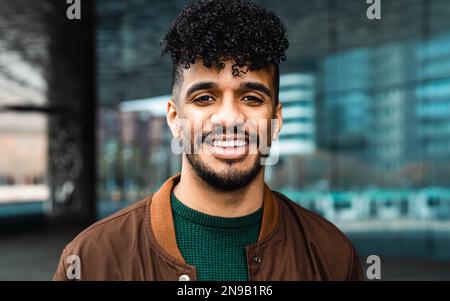 Felice giovane uomo latino sorridente davanti alla macchina fotografica Foto Stock