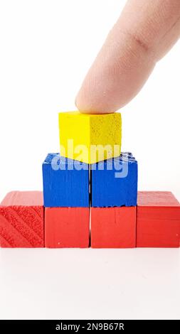 Astratto grafico a piramide multicolore 3D su sfondo bianco, con mano di uomo maturo. Foto Stock