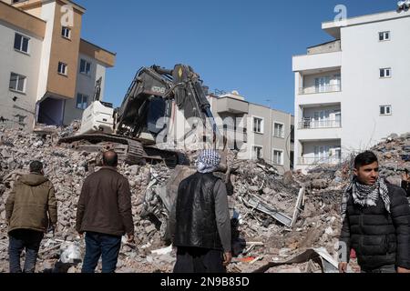 Adiyaman, Turchia. 11th Feb, 2023. La gente guarda il relitto di edifici crollati. Sono passati 6 giorni dal terremoto che ha colpito la Turchia e la Siria. Nel terremoto, in cui sono morte più di 20 mila persone, si sono verificate grandi distruzioni in Turchia e Siria. Il terremoto, che viene descritto come un disastro, ha causato oltre 20 mila persone a morire e oltre 200 mila a essere feriti finora. In Adiyaman, una delle città più colpite dal terremoto in Turchia, il lavoro continua ininterrottamente per le persone e gli animali sotto le macerie. Credit: SOPA Images Limited/al Foto Stock