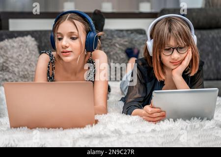 Generazione Z. i bambini adolescenti utilizzano la tecnologia moderna a casa e utilizzano cuffie, computer portatili e tablet per l'intrattenimento e l'istruzione Foto Stock