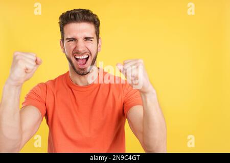 Felice uomo caucasico che festeggia mentre alza i pugni Foto Stock