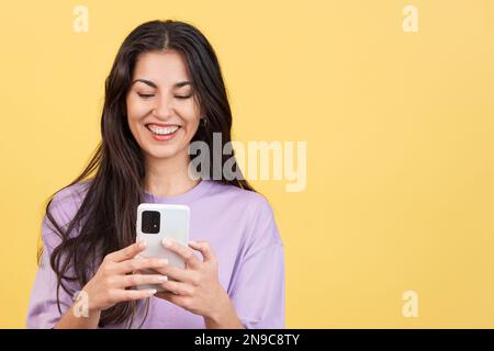 Felice donna caucasica sorridente mentre si utilizza il cellulare Foto Stock