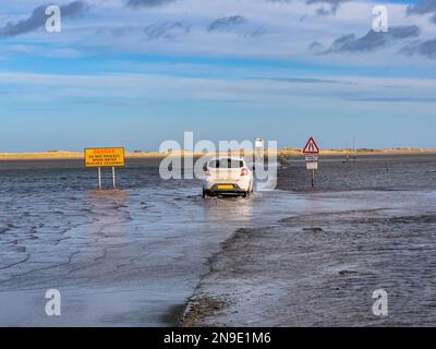 La strada sopraelevata per Lindisfarne sull'Isola Santa al largo della costa del Northumberland nell'Inghilterra nord-orientale. Passabile solo con bassa marea. Foto Stock