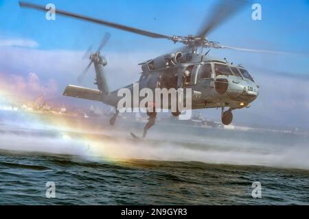 Un US Naval Aircewman (elicottero), salta da MH-60s elicottero durante l'esercizio Foto Stock