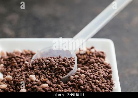 Fertilizzante organico NPK per erbe e piantine con cucchiaio dosatore Foto Stock