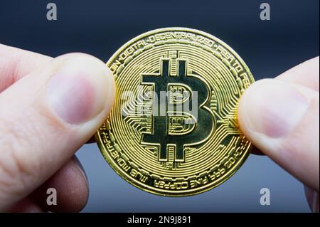 Concetto di trasferimento Bitcoin da mano a mano. Foto di alta qualità. Tenere il dito bitcoin dorato su nero isolato. Portamonete oro bitcoin cripto digitale mo Foto Stock