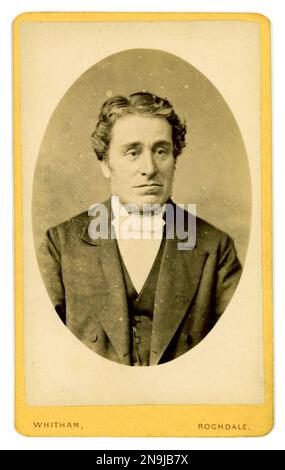 Originale CDV dell'epoca vittoriana con tonalità seppia anni '1870, gentiluomo vittoriano (carte de visite o biglietto da visita) di glum, uomo vittoriano sorridente che indossa un sacco con ampi revers, cravat, Whitham 192 Yorkshire Street Rochdale, Inghilterra, Regno Unito, circa 1875. Foto Stock