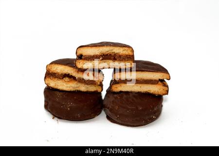 Biscotti ripieni e ricoperti di cioccolato naturale, concetto di aumento di peso, panetteria e pasticceria, focalizzazione selettiva di pila di biscotti biscotto coperto con Foto Stock