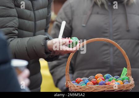 I clienti del mercato agricolo di Naplavka a Praga acquistano uova dipinte, una tradizionale decorazione pasquale nella Repubblica Ceca in inverno all'inizio Foto Stock