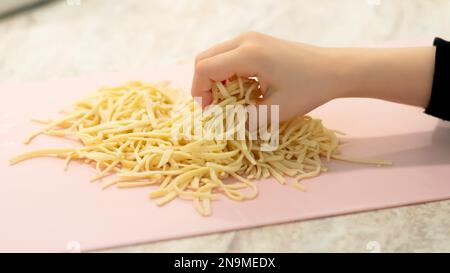 Preparare pasta fatta in casa noodles linguini. Vista frontale. Foto Stock