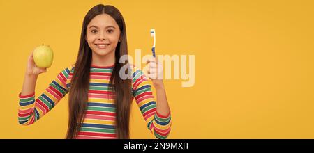 Seguire l'igiene orale. Ragazza felice tenere mela e spazzolino da denti. Igiene orale. Cura dentale. Banner di bambina con pennello denti, ritratto studio, intestazione Foto Stock