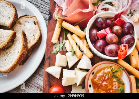 Un piatto mediterraneo con una selezione di formaggi e salumi con un piatto di fette di pane e pomodori ciliegini Foto Stock