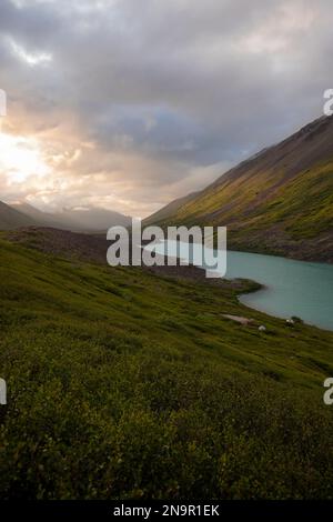 Vista mozzafiato sulle cime delle montagne e sulle acque turchesi al crepuscolo presso il lago Symphony e l'area di campagna del lago Eagle delle montagne Chugach in C... Foto Stock