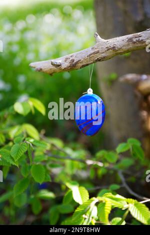 Dipinto uovo di pasqua appeso ad un albero nella foresta Foto Stock