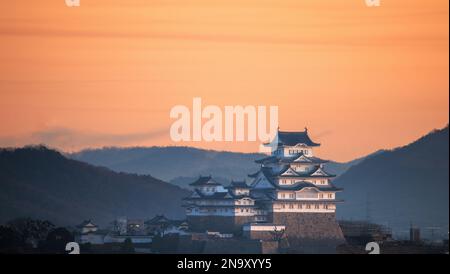 Cielo arancione sullo storico castello giapponese e sul paesaggio di Himeji all'alba Foto Stock