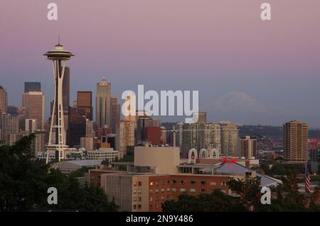 Lo skyline di Seattle (incluso lo Space Needle) al crepuscolo. MT. Rainier può essere visto in lontananza.; Seattle, Washington, USA Foto Stock