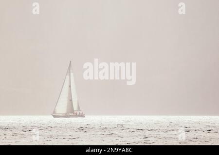 Barca a vela solitaria nella nebbia dei Caraibi. Scena dal 2011 Mt. Gay Rum yacht Race, che circumnaviga l'isola di Grenada Foto Stock