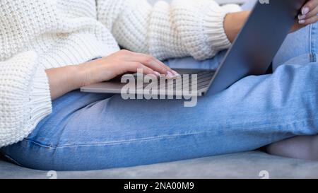 Primo piano delle mani femminili che premono la tastiera di un computer portatile. Una donna utilizza un notebook Foto Stock