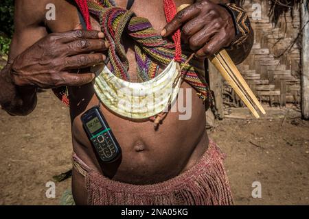 Residente nel villaggio di Wabia nelle Highlands meridionali della Papua Nuova Guinea. Il servizio di telefono delle cellule è disponibile in questa zona relativamente non sviluppata. Foto Stock