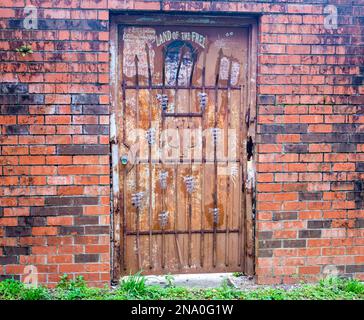 NEW ORLEANS, LA, USA - 2 FEBBRAIO 2023: Porta in metallo arrugginito e porta di sicurezza e un muro di mattoni e qualche improvvisazione artistica di un uomo dietro le sbarre Foto Stock