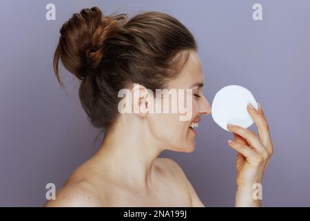 donna felice di mezza età con tampone di cotone su sfondo blu. Foto Stock