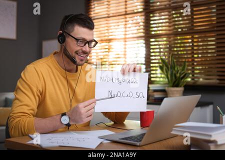 Insegnante che conduce una lezione online a casa durante la quarantena COVID-19 Foto Stock