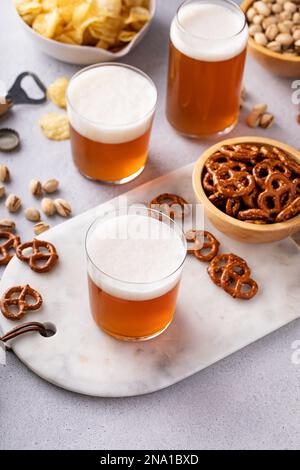 Birra lager tradizionale in vari bicchieri con spuntini diversi sul tavolo Foto Stock