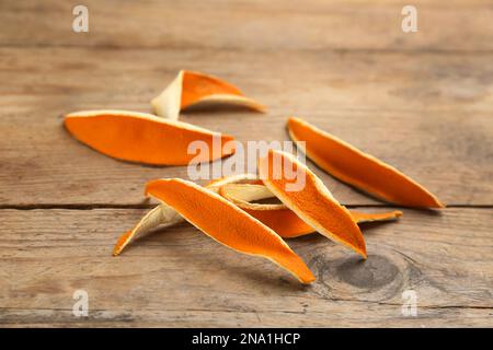Pila di bucce d'arancia secche su tavola di legno Foto Stock