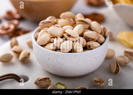 Varietà di snack salati sul tavolo con pretzel, pistacchi e patatine, snack che vanno bene con la birra Foto Stock