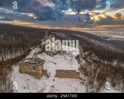 Tramonto spettacolare sul castello invernale di Korlatka nelle piccole montagne carpazi in Slovacchia Foto Stock