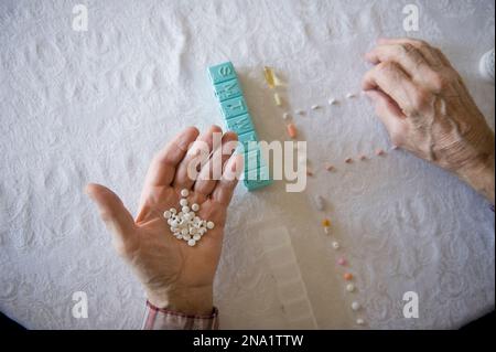 L'uomo anziano conta una settimana di pillole; Cortland, Nebraska, Stati Uniti d'America Foto Stock