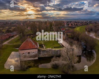 Veduta aerea del tramonto del castello di Onod con torre che si riflette sul fossato, spettacolare cielo al tramonto Foto Stock