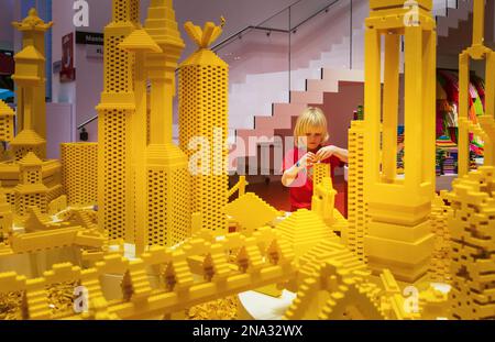 Boy building Lego Tower nella zona Rossa della Lego House; Billund, Danimarca Foto Stock