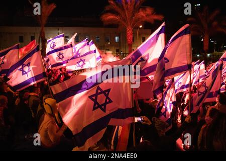 Tel Aviv, Israele. 11th Feb, 2023. I manifestanti detengono bandiere israeliane durante la manifestazione. Più di 130.000 persone hanno protestato a Tel Aviv contro il governo di estrema destra di Netanyahu ed è una controversa riforma legale. Credit: SOPA Images Limited/Alamy Live News Foto Stock