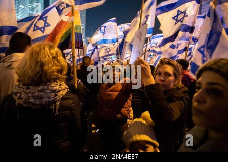 Tel Aviv, Israele. 11th Feb, 2023. I manifestanti detengono bandiere israeliane durante la manifestazione. Più di 130.000 persone hanno protestato a Tel Aviv contro il governo di estrema destra di Netanyahu ed è una controversa riforma legale. Credit: SOPA Images Limited/Alamy Live News Foto Stock