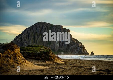 Morro Rock mentre il sole tramonta a Morro Bay, California Foto Stock