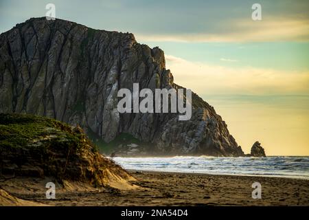 Morro Rock mentre il sole tramonta a Morro Bay, California Foto Stock