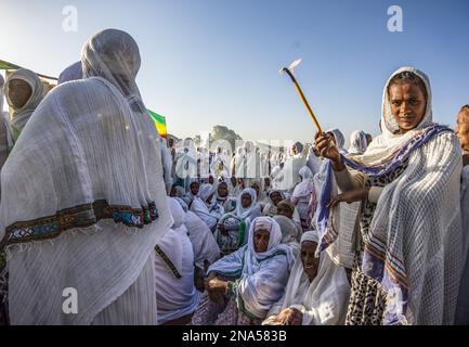 Donna che tiene in mano una candela accesa alla cerimonia Timkat durante la celebrazione ortodossa Tewahedo dell'Epifania, celebrata il 19 gennaio Foto Stock