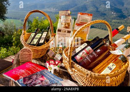 Cesti di bottiglie di olio d'oliva e vino e opuscoli che pubblicizzano le industrie alimentari tradizionali; Motovun, Croazia Foto Stock