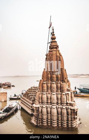 Tempio parzialmente sommerso nella cremazione di Manikarnika ghat; Varanasi, Uttar Pradesh, India Foto Stock