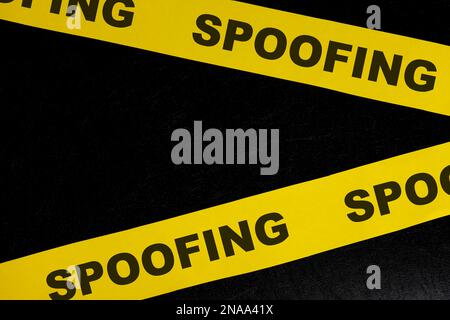 Spoofing del concetto di allarme, attenzione e avvertimento di criminalità informatica. Nastro barricata giallo con spoofing di parola su sfondo nero scuro. Foto Stock