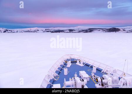 La prua di una nave puntava verso il ghiaccio veloce a Deception Island, South Shetlands, Antartide; South Shetland Islands, Antartide Foto Stock