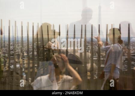 In cima all'Arco di Trionfo, i turisti che scattano fotografie e la Torre Eiffel si riflettono nelle finestre di Parigi, Francia; Parigi, Francia Foto Stock