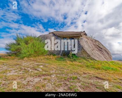Casa di Boulder o Casa do Penedo, una casa costruita tra enormi rocce sulla cima di una montagna a Fafe, Portogallo. Foto Stock