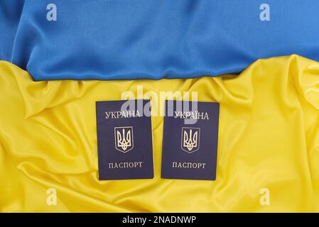 Passaporti dei cittadini Ucraina su sfondo blu e giallo della bandiera Ucraina. Sostegno del paese durante l'occupazione. Foto Stock