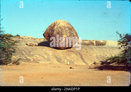 Krishna's Butterball è una gigantesca roccia equilibrante, granito-boulder che riposa su una breve pendenza nella storica località turistica costiera di Mamallapuram, nello stato indiano del Tamil Nadu. Alcuni dicono che potrebbe essere dovuto all'attrito e al centro di gravità. Foto Stock